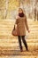 Young blond fashion woman in classic beige coat walking outdoor