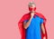Young blond man wearing super hero custome feeling unwell and coughing as symptom for cold or bronchitis