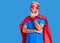 Young blond man wearing super hero custome with hand on chin thinking about question, pensive expression