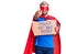 Young blond man wearing super hero custome holding power to the people cardboard banner pointing with finger to the camera and to