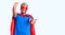 Young blond man wearing super hero custome looking at the camera smiling with open arms for hug