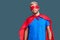 Young blond man wearing super hero custome relaxed with serious expression on face