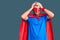 Young blond man wearing super hero custome suffering from headache desperate and stressed because pain and migraine
