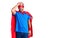 Young blond man wearing super hero custome surprised with hand on head for mistake, remember error