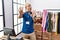 Young blond man working as manager at retail boutique afraid and terrified with fear expression stop gesture with hands, shouting