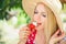 Young blond woman eating strawberries with cream, happy in the garden on a summer sunny day, warm summer tonic image, self-service