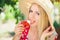 Young blond woman eating strawberries with cream, happy in the garden on a summer sunny day, warm summer tonic image, self-service