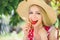 Young blond woman eating strawberries smiling in the garden summer sunny day, warm summer toning image, self care and healthy life