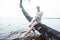 Young blond woman hanging on birch tree at lake shore, summer vacations outdoor lifestyle