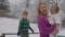 Young blond woman with her kids enjoying in snow park