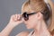 Young blond woman holding modern sunglasse