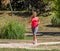 Young blond woman jogging and listening to music in park