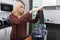 Young blond woman juicing carrots in kitchen