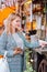 Young blond woman paying contactless by credit card in street cafe