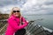 Young blond woman poses and enjoys the scenery along the Cliff Walk in Newport Rhode Island