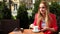 Young blond woman sitting on chair in coffee shop, drinking beverage