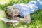 Young blond woman sleeping with a book in the park. Rest at nature. Top view