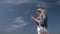 Young blond woman with a smartphone in hand against blue sky Slow motion Bottom view