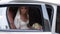 Young blonde bride sitting in car