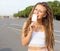 Young blonde girl with dreads eating white ice cream in summer hot evening, have fun and good mood looking in camera and smi