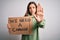 Young blonde girl holding protest banner for political problems and planet activism with open hand doing stop sign with serious