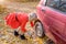 Young blonde girl replace car wheel on the roadside