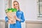 Young blonde girl smiling happy holding groceries paper bag standing at the city