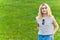 young blonde girl standing confidently in the park. medium shot grass