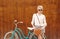 Young blonde girl is standing near the vintage green bicycle with brown vintage bag in orange sunglasses, warm, tonning