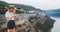 Young blonde girl takes photo of  panorama landscape on retro camera during  trip on mountains outdoors, hipster tourist in summer