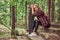 Young blonde hipster girl resting in a park, after riding on the skateboard.