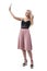 Young blonde influencer girl in stylish elegant classy fashion taking selfie holding hair