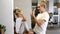 Young blonde mother with a little daughter in a decorated new year`s house playing with their hands