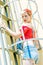 Young blonde pinup girl with a red bow on a emergency stairway. Concept pinup woman