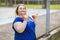 A young blonde of plus size does exercises with dumbbells on the street. Healthy lifestyle concept