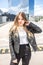 Young blonde schoolgirl in black leather jacket posing in the parking lot