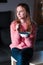 Young blonde smiling girl enjoying eating fresh blueberries holding small bowl full of fruits