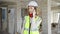 Young blonde woman architect talking on smartphone at construction site