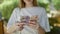 Young blonde woman counting swedish krone banknotes at park