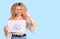 Young blonde woman with curly hair holding scribble draw annoyed and frustrated shouting with anger, yelling crazy with anger and