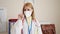 Young blonde woman doctor saying no with finger wearing medical mask at clinic