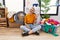 Young blonde woman doing laundry sitting by washing machine waiving saying hello happy and smiling, friendly welcome gesture