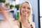 Young blonde woman florist make selfie by the camera at florist store