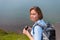 A young blonde woman holding binoculars and posing for the camera. Concept of leisure and Hiking