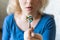 Young blonde woman holding a full spoon of assorted pills in front of her open mouth