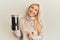 Young blonde woman holding jar with coffee beans smiling happy pointing with hand and finger