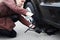 A young blonde woman jacks up the car near her car with a flat tire