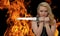 Young blonde woman with a knife in the fire