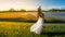 Young blonde woman in landscape with peaceful face during sunset skirt hair blown by the wind. Yellow soft light