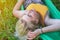 Young blonde woman lies in green tourist hammock on nature